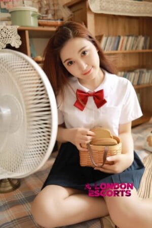 Gloria Korean Bond Street Escort posing by a fan