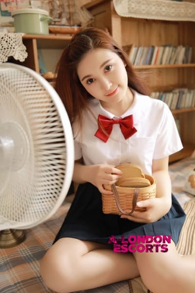 Gloria Korean Bond Street Escort posing by a fan