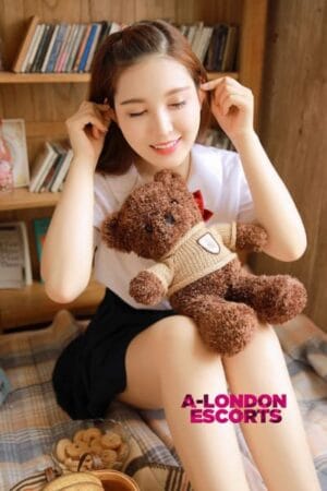 smiling chinese escort with a teddy on her knee