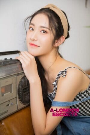 Eko Japanese Teen Escort smiling near her radio