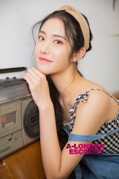 Eko Japanese Teen Escort smiling near her radio