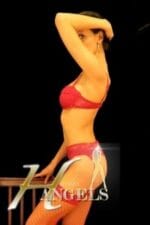 petite Southampton escort poses near a bannister in red lingerie