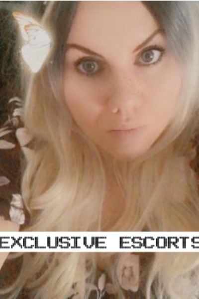 blonde Essex escort with butterfly looking at the camera
