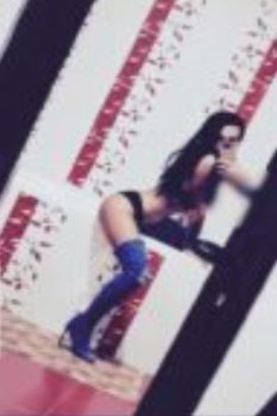 long haired Birmingham escort party girl posing in knee high boots