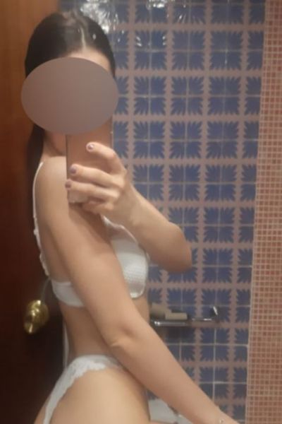 young Carlisle escort taking selfie in mirror wearing white