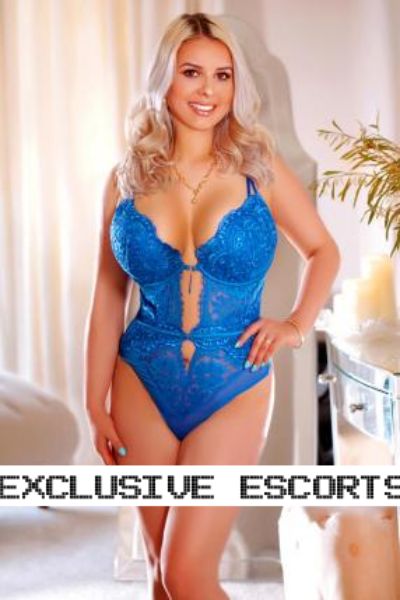 Super Busty London Escort modelling in a sexy blue outfit