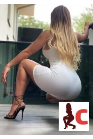 shapely Glasgow escort in high heels and white dress