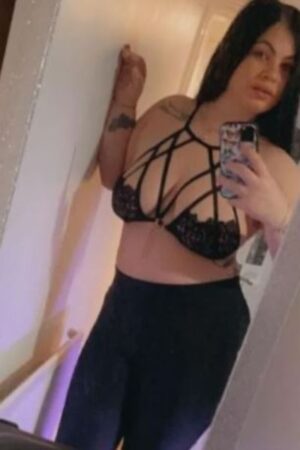 busty brunette Derby escort in a lacy black bra