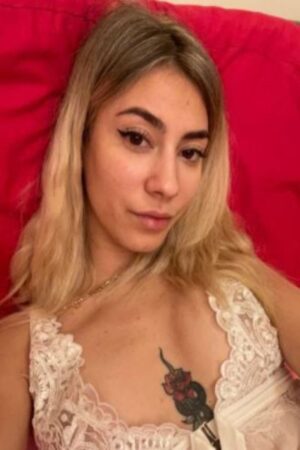 young blonde Derby escort with rose chest tattoo