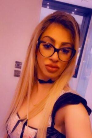 blonde Cambridge escort in glasses and maid outfit