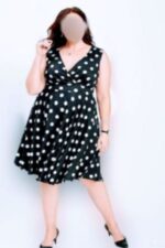 Curvy Luton escort wearing a white polka dot black dress