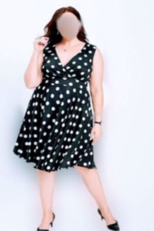 Curvy Luton escort wearing a white polka dot black dress