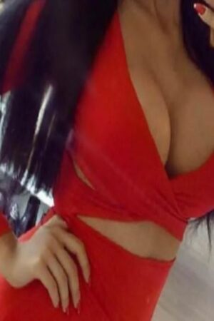 busty Chelmsford escort in red cross dress