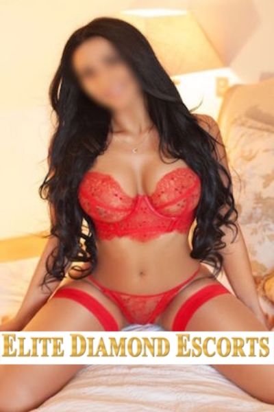 busty Nottingham escort with flowing hair in red lingerie