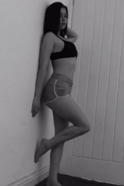 young Bolton escort with her foot up on wall