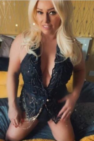 mature blonde Leeds escort kneeling on bed