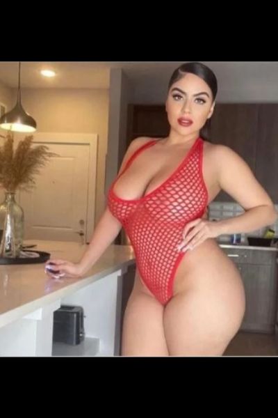 busty and curvy Wigan escort in red bodice