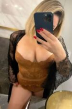 busty Chester companion takes a selfie in brown lingerie