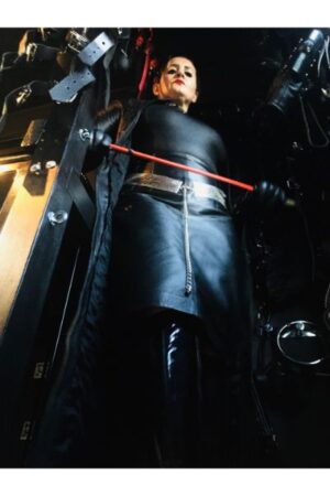 Lady Amber holding a red whip