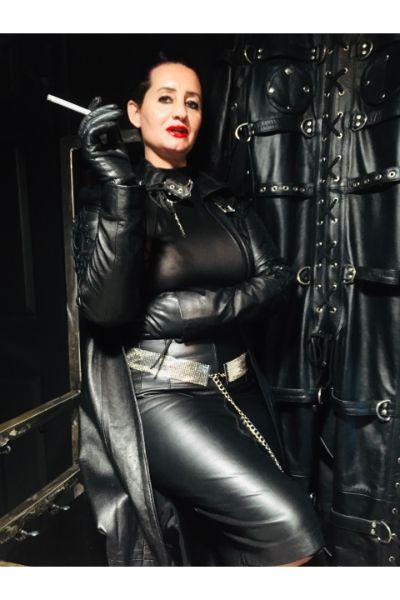 Lady Amber in black leather smoking a cigarette