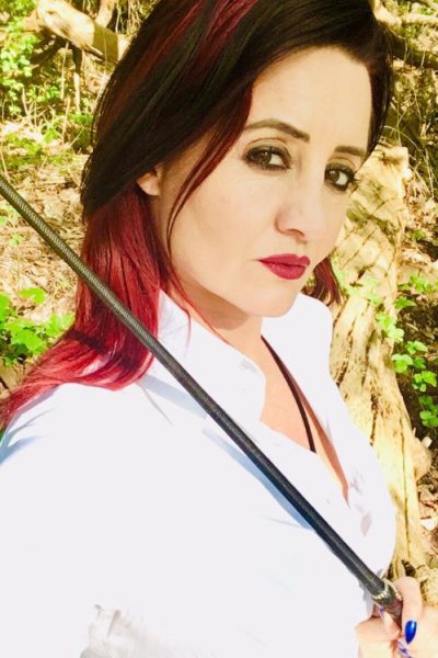 Lady Amber holding a whip