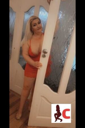 Curvy Mature Athlone Escort posing by the door