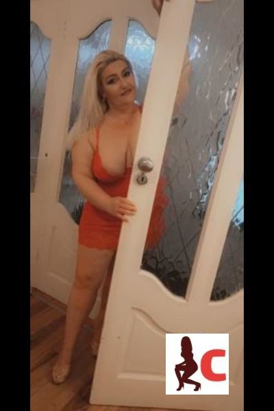 Curvy Mature Athlone Escort posing by the door