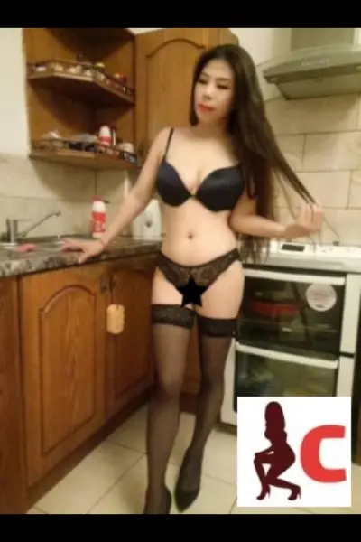 Asian escort poses in her kitchen