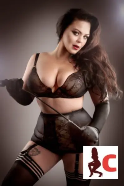 Irish Miss Scarlett in black holding a whip