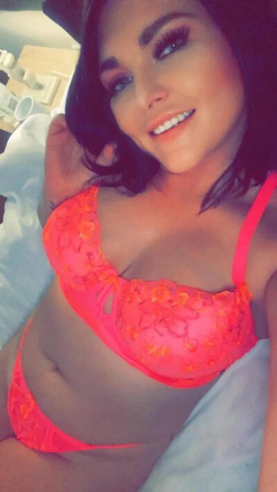 Smiling escort laid in her bed