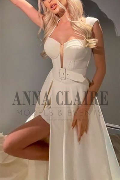 Blonde escort wearing a white dress