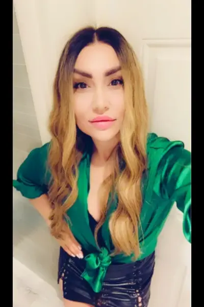 Curly Blonde haired Escort in leather skirt