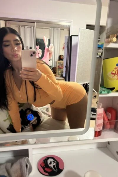 Busty brunette escort in orange pyjamas