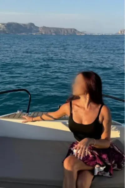 Brunette escort on a boat in the ocean