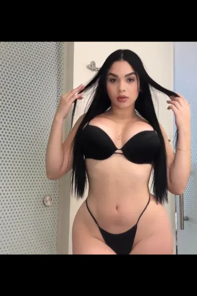 Busty raven haired escort in a black bikini