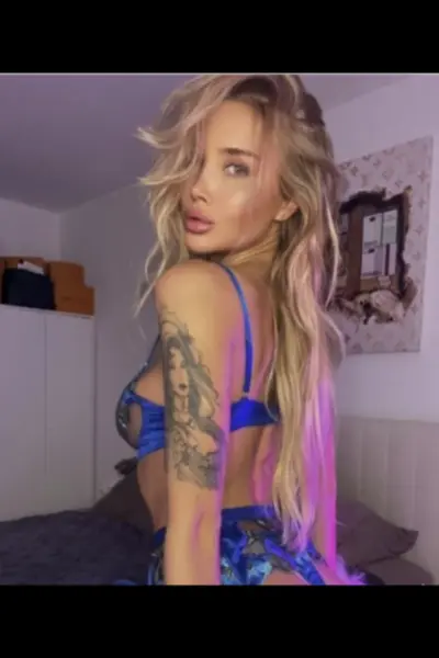 Petite tattooed blonde escort in blue lingerie